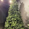 Tall green artificial Christmas tree displayed indoors