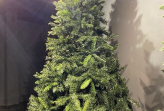 Tall green artificial Christmas tree displayed indoors